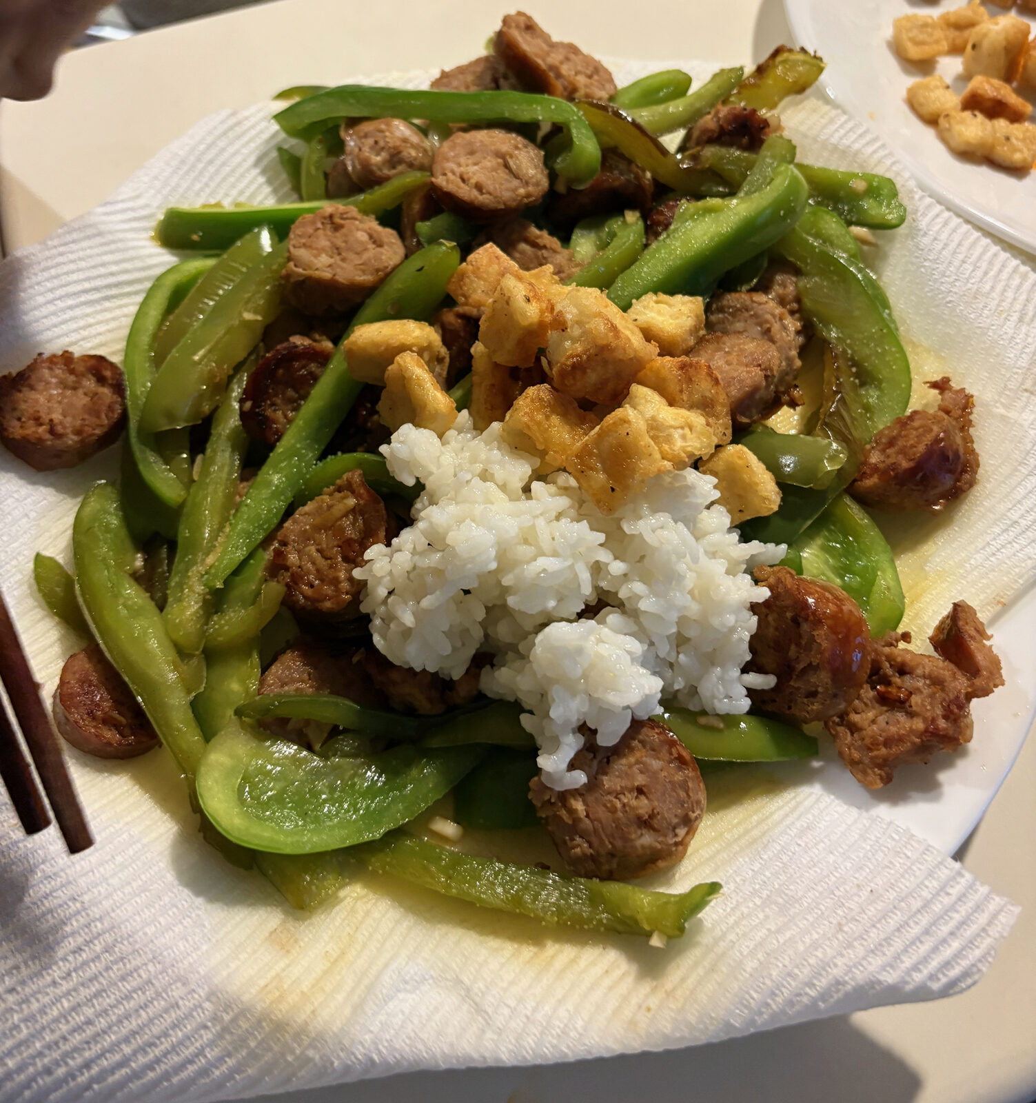 Crispy tofu served with rice, peppers, and sausage